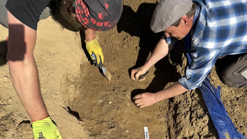 Archeologové z ARÚ AV ČR,  Praha,  opatrně začišťují zbytek nádoby,  ve které byl depot stříbrných mincí z přelomu 11. a 12. století původně uložen | Foto: Archeologický ústav AV ČR