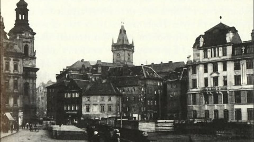 Pohled na Kaprovu ulici směrem ke Staroměstskému náměstí (kolem 1914). Nalevo je nová budova, která byla postavena na místě Kafkova rodného domu, foto: Public Domain Pohled na Kaprovu ulici směrem ke Staroměstskému náměstí (kolem 1914). Nalevo je nová budova, která byla postavena na místě Kafkova rodného domu, foto: Public Domain