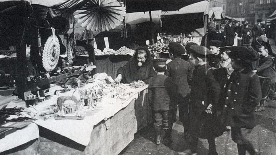 Prodavačka známá jako „bába Aušus“ na Staroměstském náměstí, kolem roku 1910 Prodavačka známá jako „bába Aušus“ na Staroměstském náměstí, kolem roku 1910