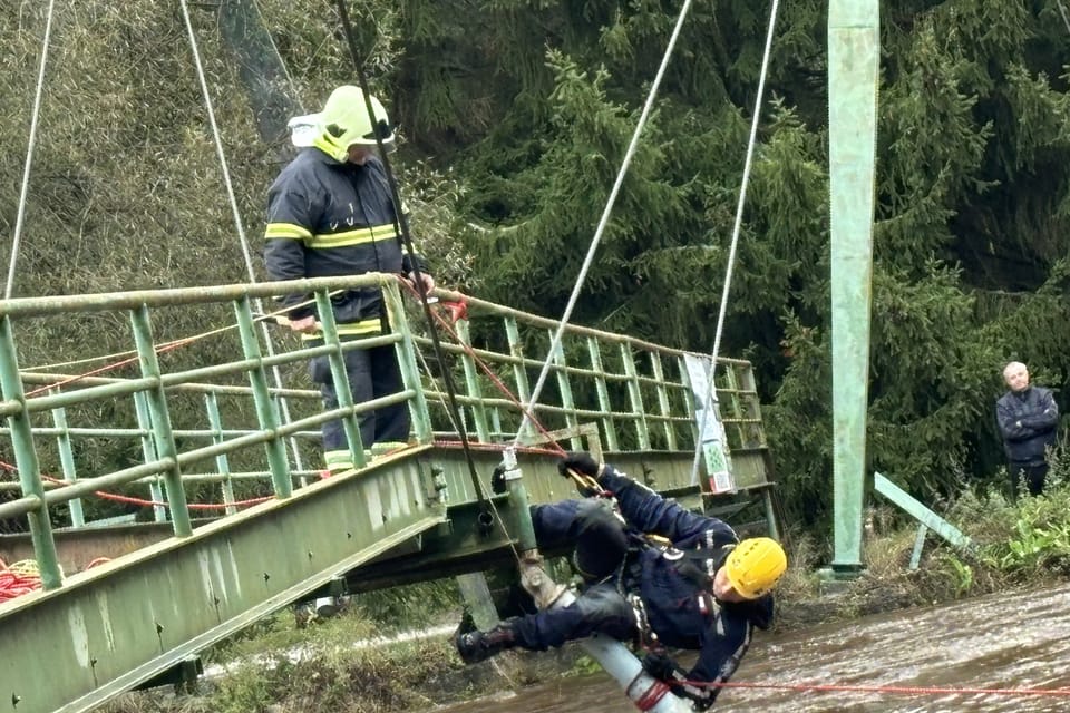 Hasiči z národního parku Šumava  (velitel Petr Šrail na laně) odstraňují z mostu přes Otavu v Anníně na Sušicku železnou podpěru,  aby se na ni nechytaly klády a další materiál | Foto: Ľubomír Smatana,  Český rozhlas